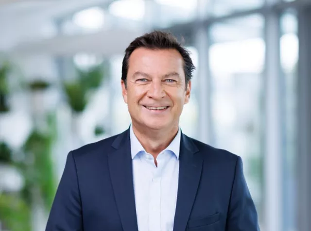 Headshot of Gabriel Rotella​, man with dark hair wearing blue blazer with white shirt smiling at camera 