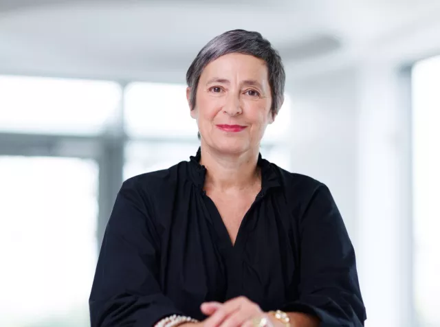 Headshot of Laure Pourageaud​, woman with short grey hair, wearing a black shirt 
