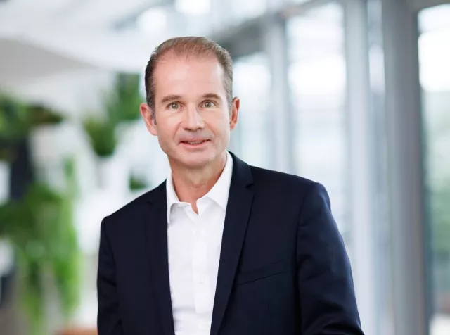 Headshot of Stephane Lhopiteau, older man with light brown hair wearing a dark blue blazer with white shirt 
