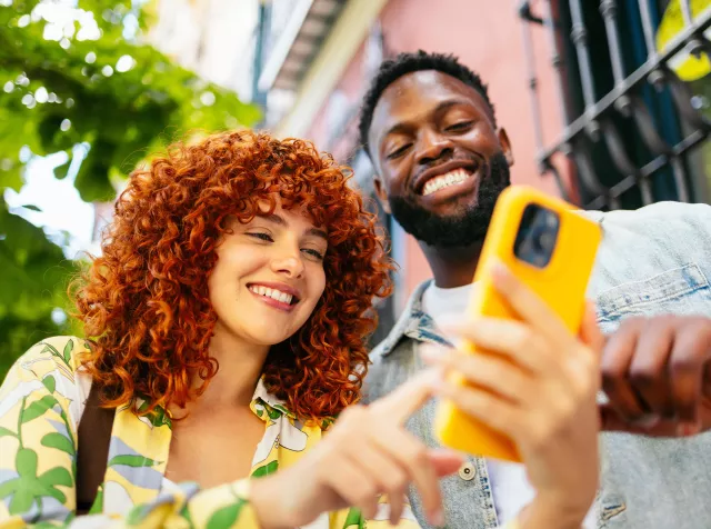 Woman and man looking at the yellow phone