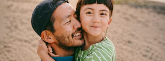 Father and daughter hugging on the beach