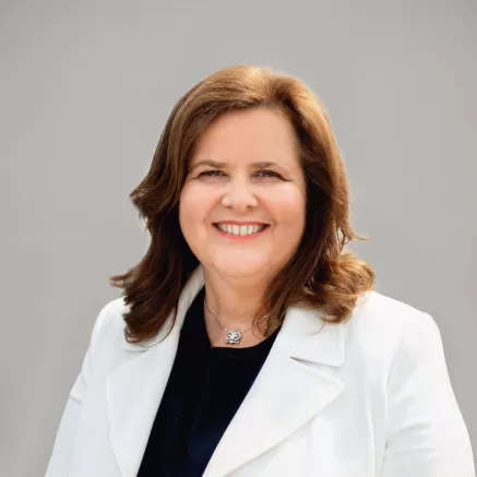 Headshot of Nathalie Bellon, older woman with brown hair in a white blazer looking at the camera smiling 