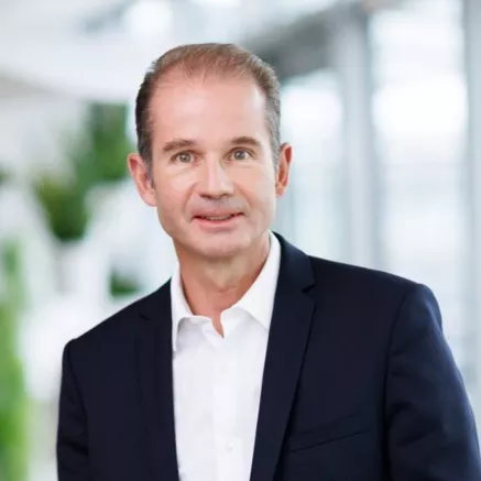 Headshot of Stephane Lhopiteau, older man with light brown hair wearing a dark blue blazer with white shirt 